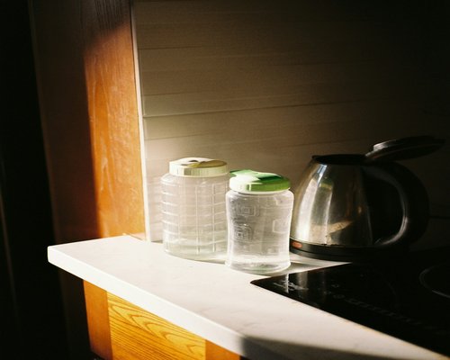 A glass pitcher of fresh water with ice on a sunny kitchen counter
